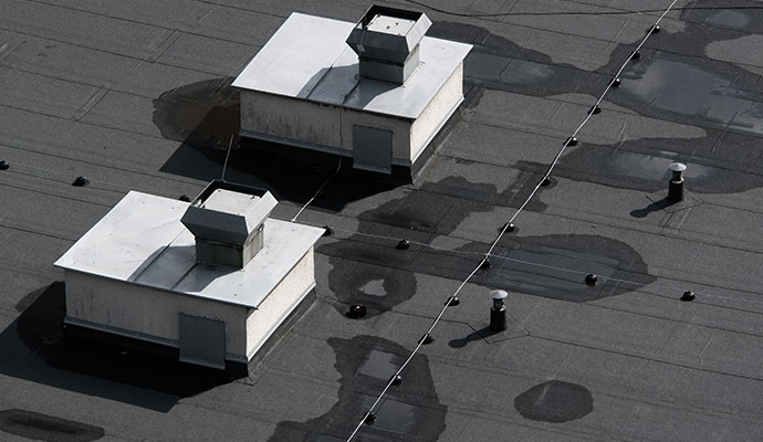 Commercial flat roof with visible water stains on the surface
