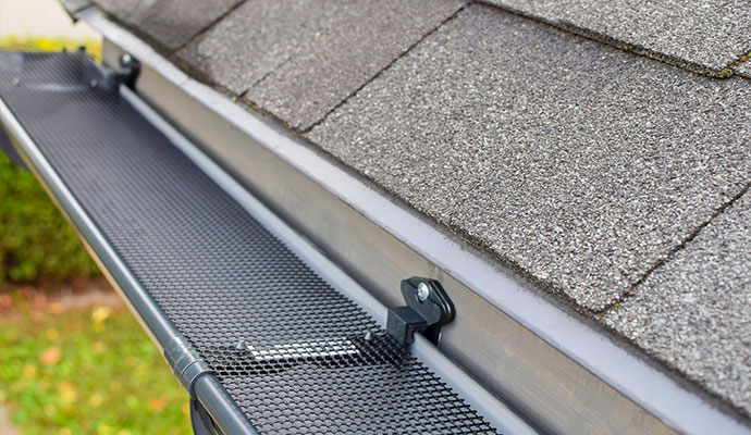 Black mesh gutter guard installed on a roof gutter