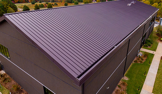 Commercial building metal roof with installed gutter system