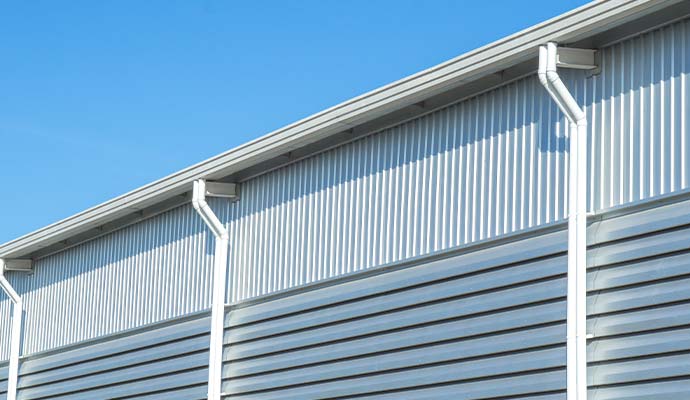 Commercial warehouse building with installed gutters and downspouts