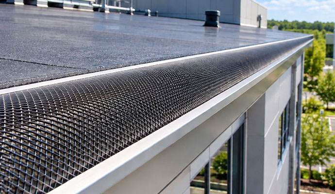 Curved mesh gutter guard installed on a commercial flat roof
