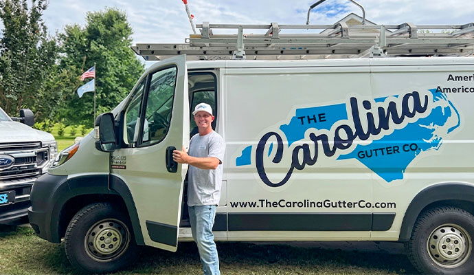 Technician standing beside The Carolina Gutter Co. service van