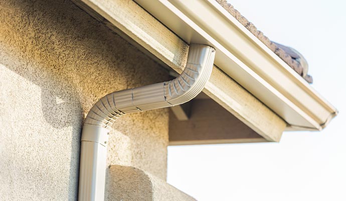 Aluminum downspout elbow connected to a roof gutter