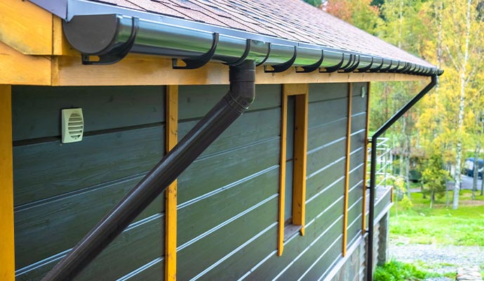 A home exterior featuring professionally installed aluminum gutters and downspouts designed for long-lasting water protection.