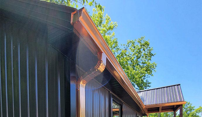 A repaired downspout securely attached to a building exterior, ensuring proper rainwater drainage from the roof.
