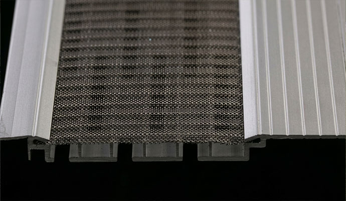 A cross-section view of a professional-grade aluminum gutter guard featuring a fine stainless steel mesh micro-screen