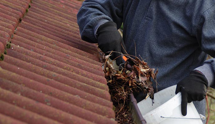 A person cleaning gutter