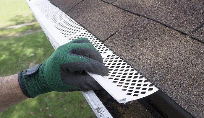 Professional worker installing gutter guard