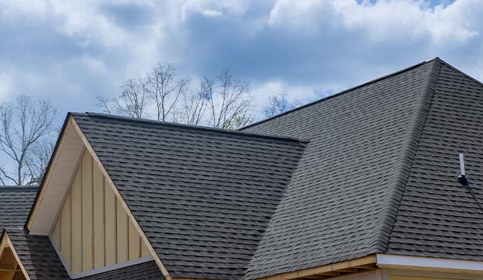 A residential roof with repaired asphalt shingles, representing professional roof repair completed by certified roofing experts.