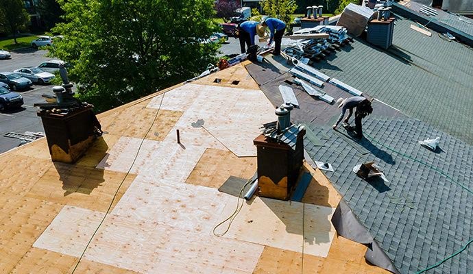 A roofing crew replacing an old roof with new materials, ensuring long-term protection and durability.