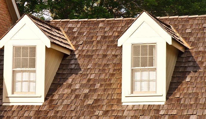 Shake-style roof of a residential house with dormer windows
